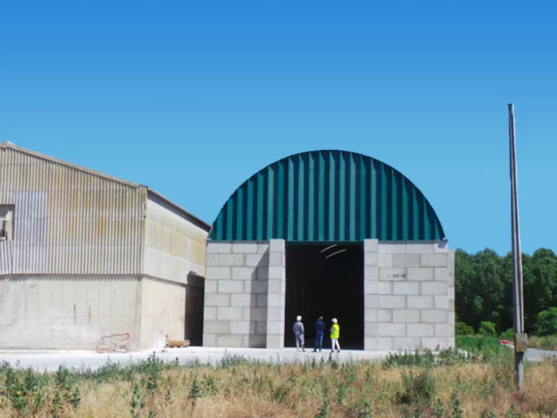 Hangar dôme acier BROOF T3 avec murs béton et large ouverture pour camions, solution industrielle conforme sécurité incendie ICPE