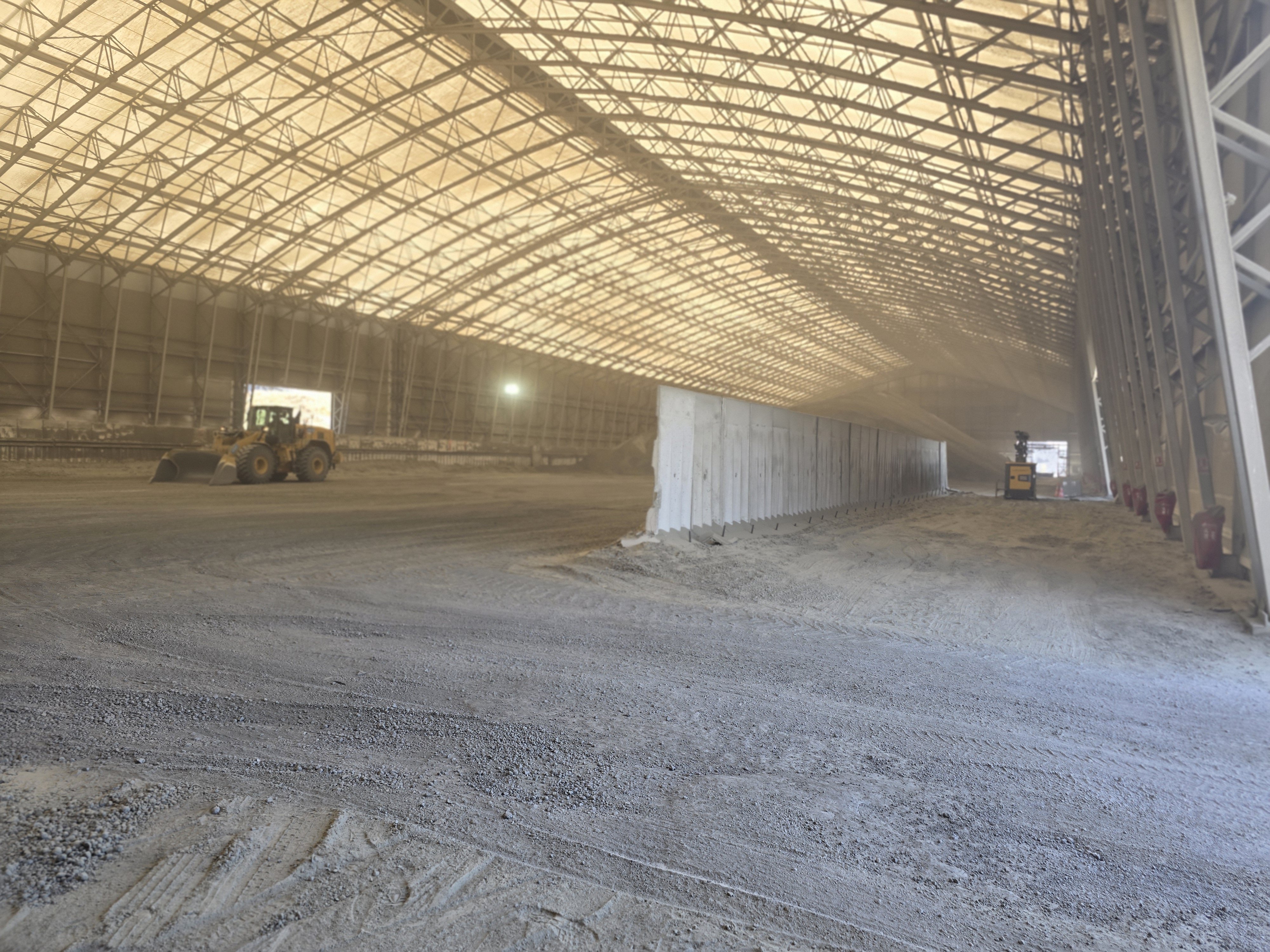 Bâtiment de stockage en vrac industriel avec mur béton de séparation et engins de manutention pour granulats ou déchets