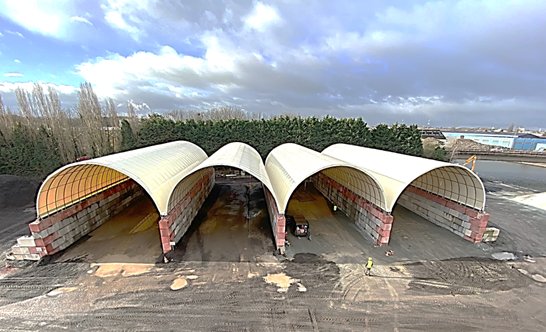 bâtiment dôme métallo textile sur blocs béton LEGO pour stockage vrac industriel granulats sable recyclage structure modulable sans fondations