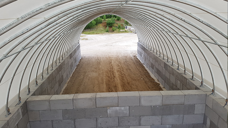 intérieur bâtiment dôme métallo textile avec murs béton LEGO stockage vrac ventilation naturelle protection pluie vent UV