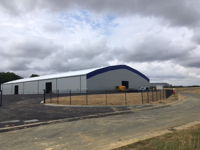Hangar industriel modulable de stockage extérieur en structure métallotextile avec accès logistique et zone industrielle