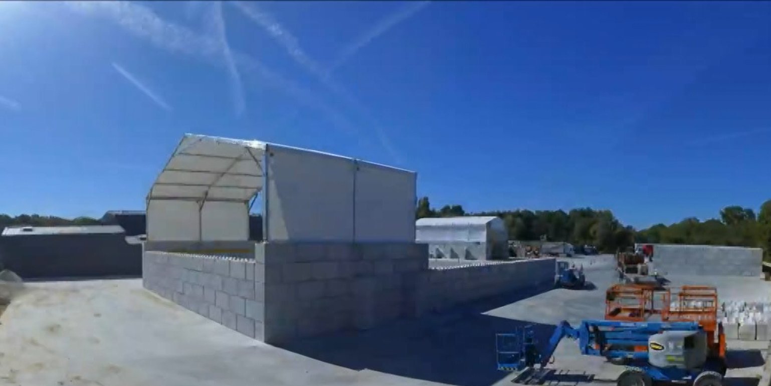 Hangar deux pans grande portée pour stockage industriel avec structure aluminium et murs béton