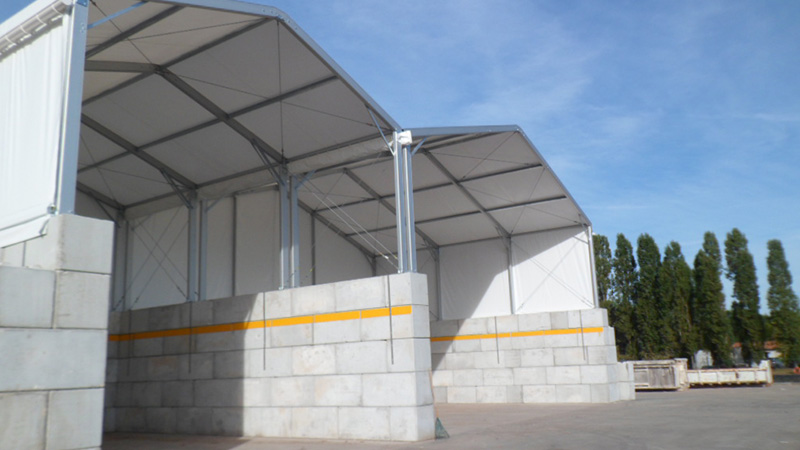Stockage  déchets vrac sous bâtiment industriel deux pentes avec murs béton résistants aux engins et matériaux lourds